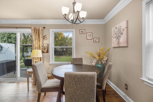 dining room with crown molding, wood-type flooring, and a notable chandelier