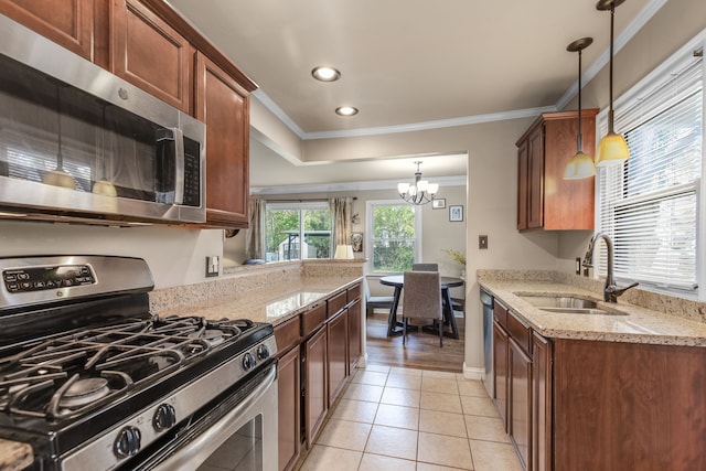 kitchen featuring pendant lighting, sink, light stone counters, and stainless steel appliances