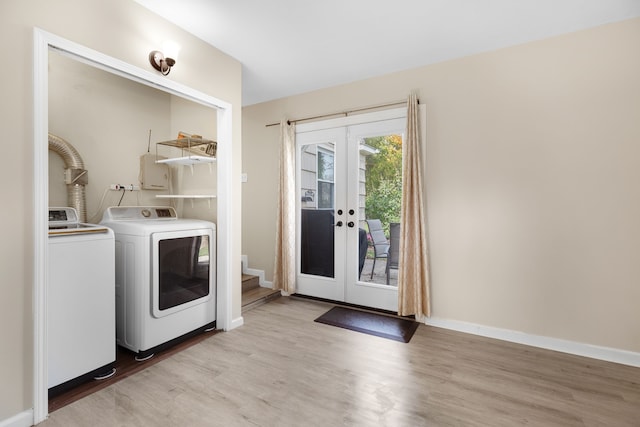 washroom with light hardwood / wood-style flooring, washer and dryer, and french doors