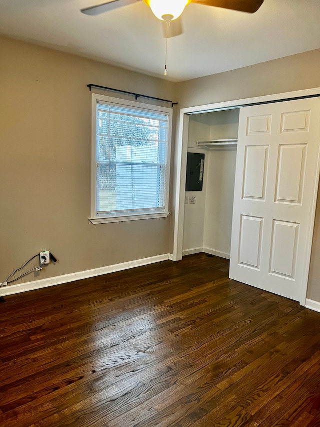 unfurnished bedroom featuring ceiling fan, dark hardwood / wood-style flooring, electric panel, and a closet