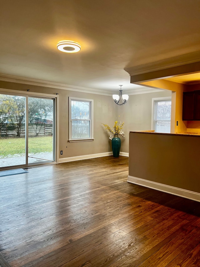 unfurnished room featuring crown molding, dark wood-type flooring, and a chandelier