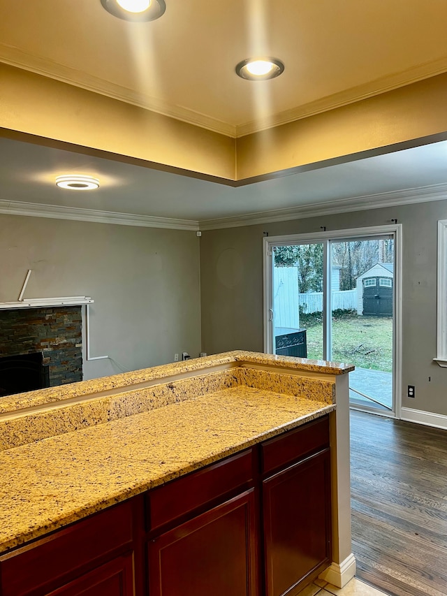 kitchen with crown molding, light stone countertops, and hardwood / wood-style flooring