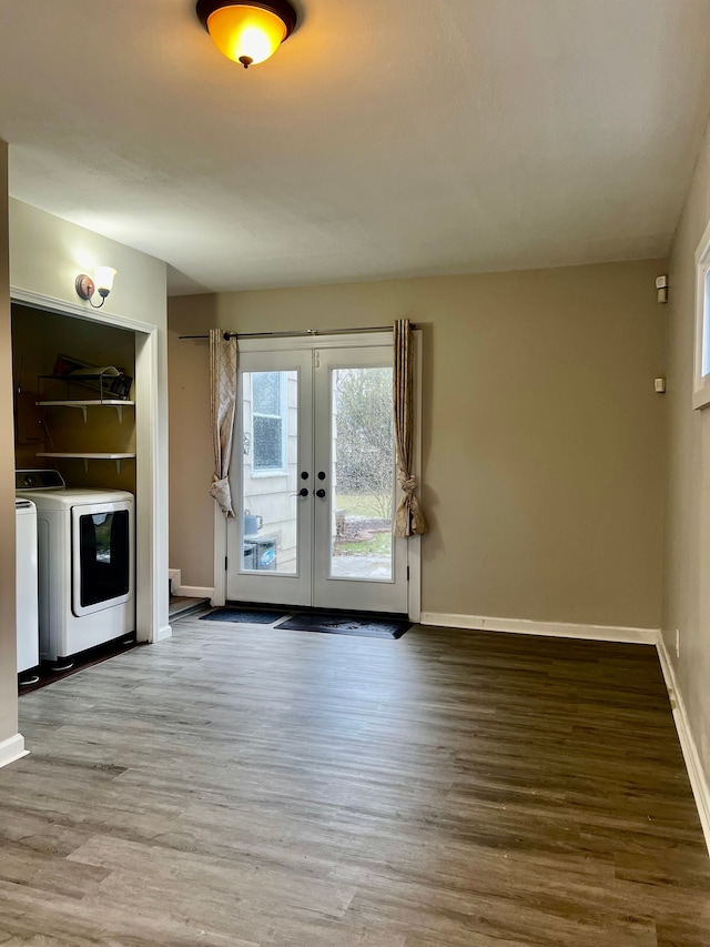 unfurnished living room featuring hardwood / wood-style flooring, washing machine and dryer, and french doors