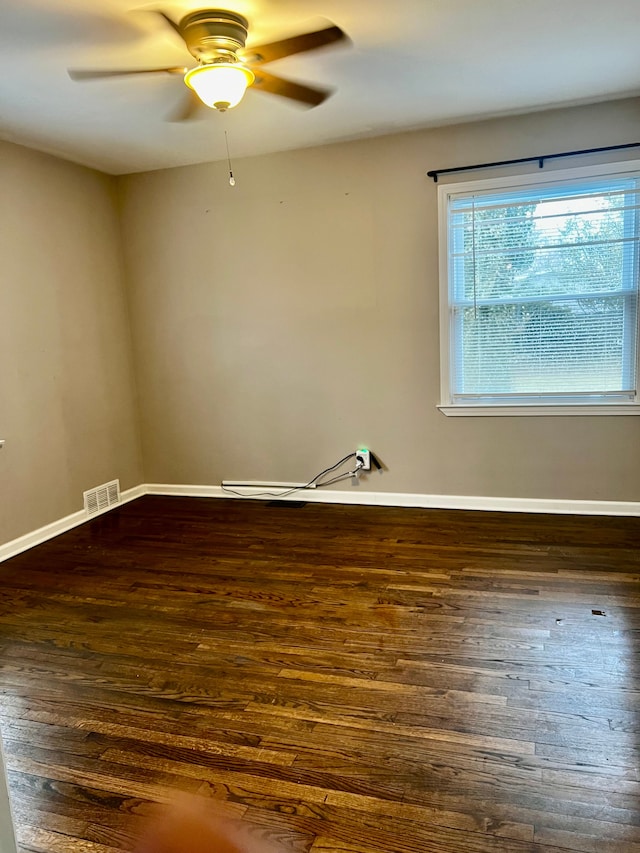 spare room with dark wood-type flooring and ceiling fan