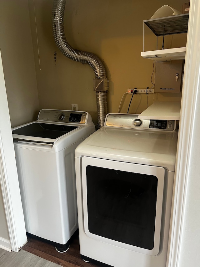 laundry area with dark hardwood / wood-style floors and washing machine and clothes dryer