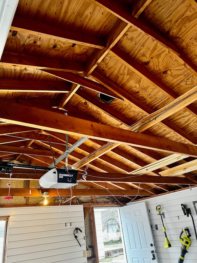 interior details with a garage door opener, wooden walls, and wooden ceiling