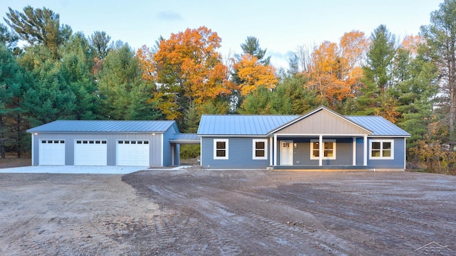 2210 Fox Run Rd, West Branch, MI 48661 - ranch-style home featuring dirt driveway, metal roof, a porch, and a detached garage