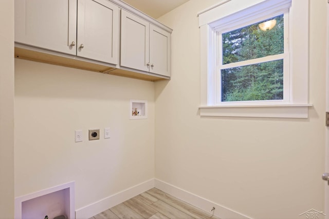 laundry room featuring light hardwood / wood-style floors, hookup for a washing machine, cabinets, and hookup for an electric dryer