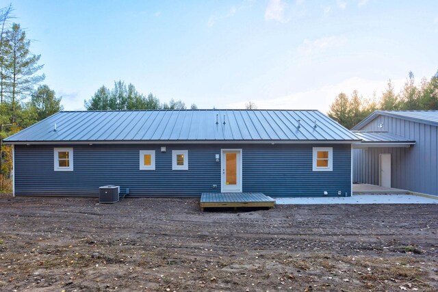 2210 Fox Run Rd, West Branch, MI 48661 - back of property featuring metal roof, central AC unit, and a deck