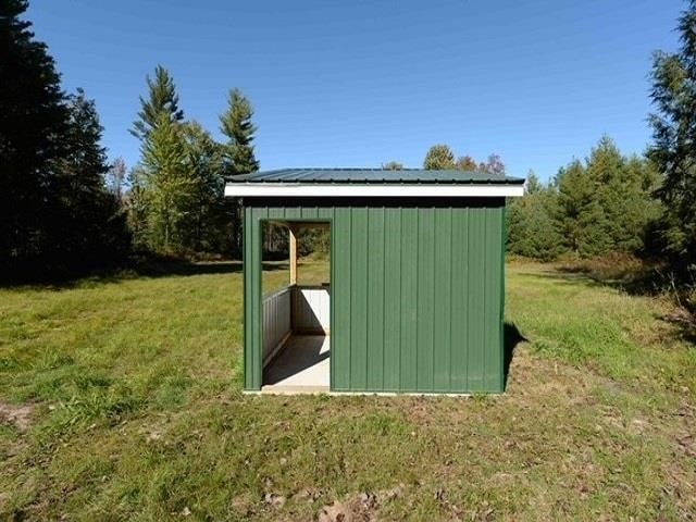 view of outbuilding featuring a lawn