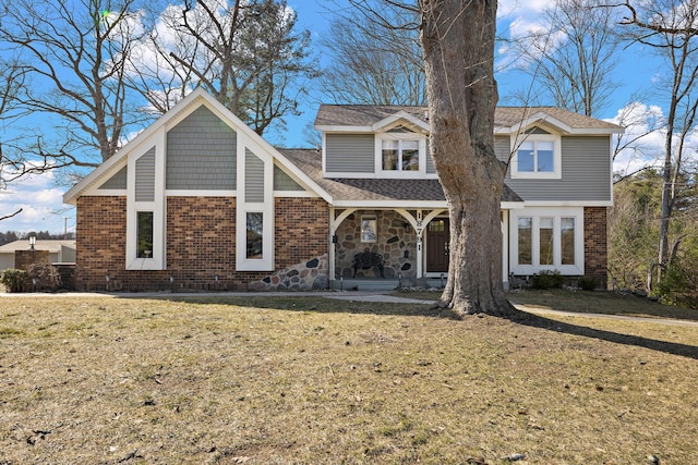 back of property with roof with shingles, brick siding, a porch, and a yard