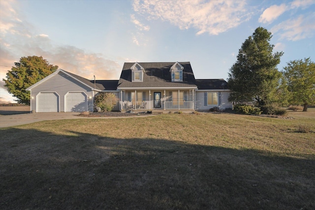 cape cod house with a lawn, a garage, and covered porch