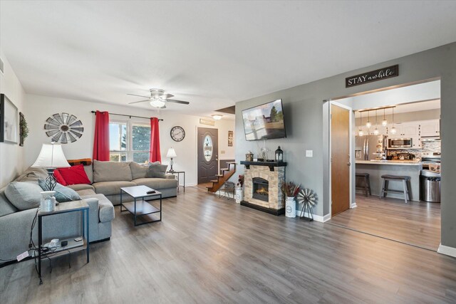 16248 Wabash Rd, Waldron, MI 49288 - living room featuring wood finished floors, a ceiling fan, baseboards, and a fireplace