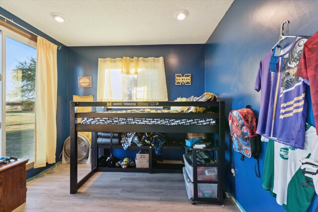 bedroom featuring hardwood / wood-style flooring and a textured ceiling