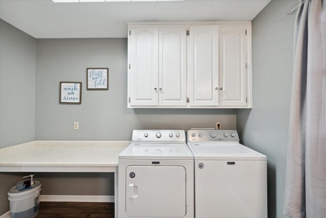 laundry area featuring cabinets, wood-type flooring, and separate washer and dryer