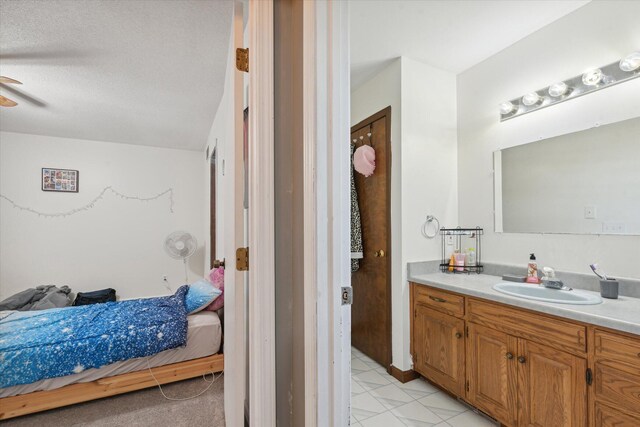 bathroom featuring tile patterned floors, vanity, ceiling fan, and a textured ceiling