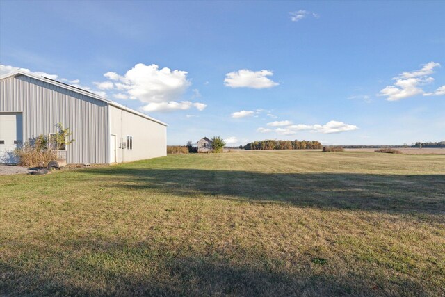 view of yard with a rural view and an outdoor structure