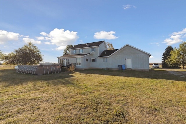 back of house with a lawn and a swimming pool