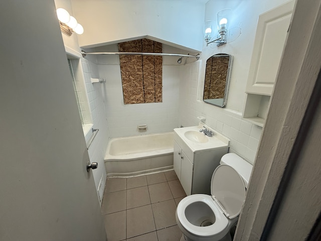 full bathroom with vanity, tile patterned floors, tiled shower / bath combo, toilet, and tile walls