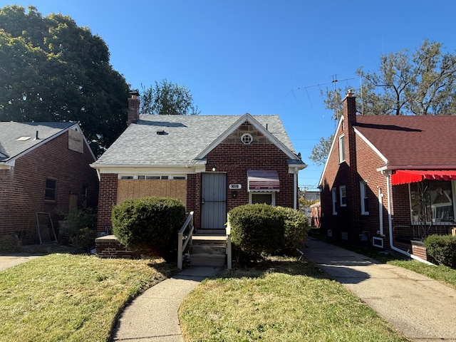 bungalow-style house with a front lawn