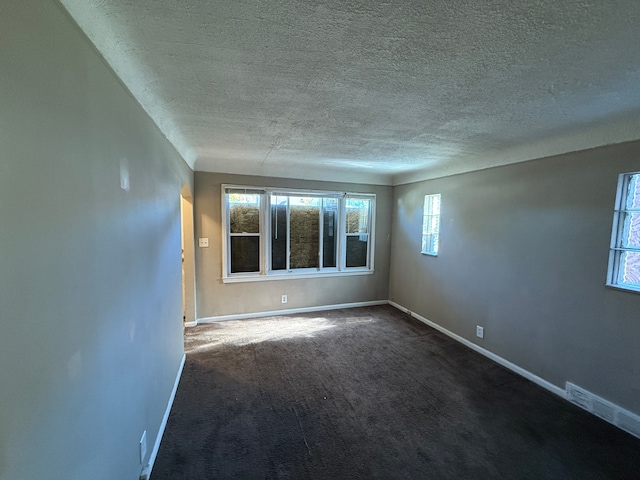 carpeted empty room with a textured ceiling