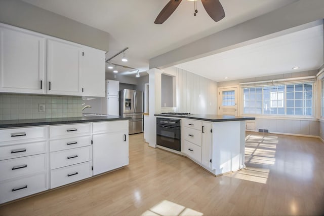 kitchen with decorative backsplash, appliances with stainless steel finishes, ceiling fan, light hardwood / wood-style flooring, and white cabinetry