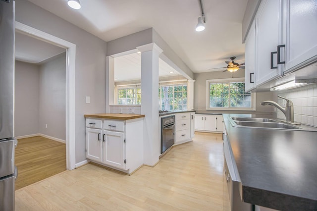 kitchen featuring white cabinets, sink, a wealth of natural light, and tasteful backsplash