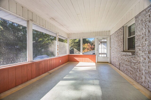 unfurnished sunroom with plenty of natural light and wooden ceiling