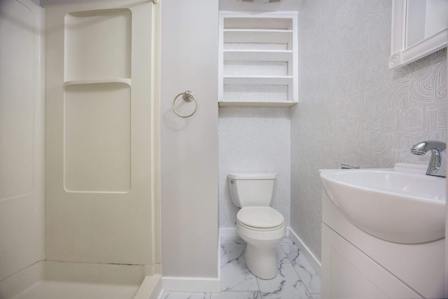 bathroom featuring vanity, toilet, and a shower