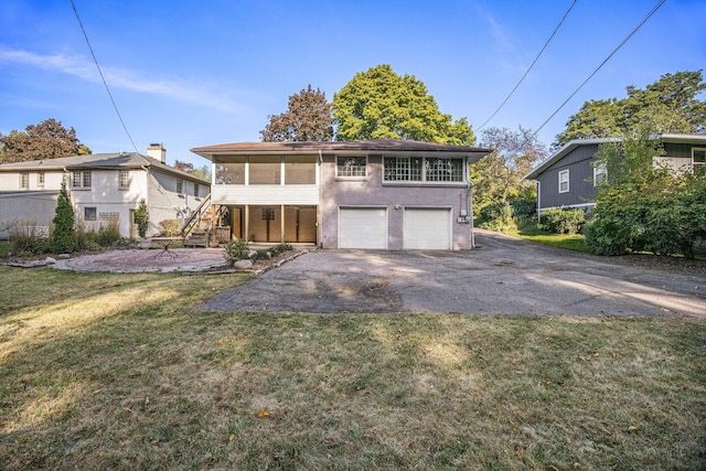 view of front property with a sunroom, a front lawn, and a garage