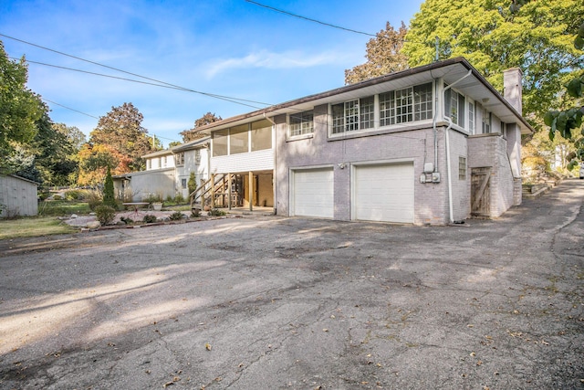 view of front property featuring a garage and a sunroom