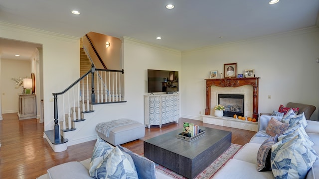 living room featuring a fireplace, hardwood / wood-style flooring, and ornamental molding