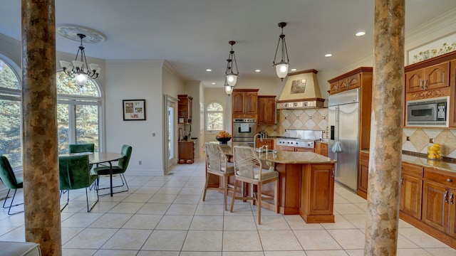 kitchen featuring built in appliances, plenty of natural light, custom range hood, and a kitchen island with sink