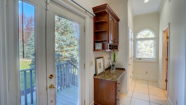 doorway featuring light tile patterned floors, a wealth of natural light, and ornamental molding