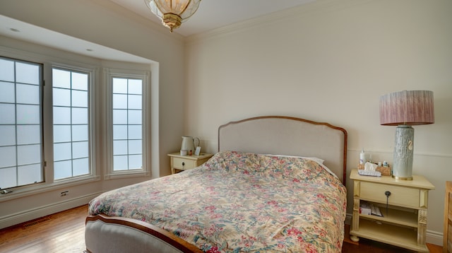 bedroom featuring hardwood / wood-style floors and ornamental molding