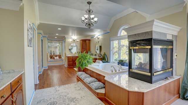 bathroom with hardwood / wood-style floors, vanity, ornamental molding, and a chandelier