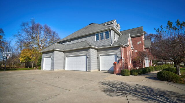 5280 O Connor Pass, Swartz Creek, MI 48473 - view of property exterior featuring concrete driveway, roof with shingles, and an attached garage