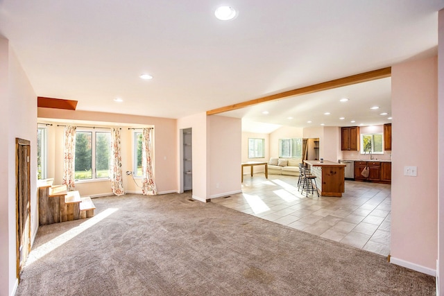 unfurnished living room featuring sink and light carpet