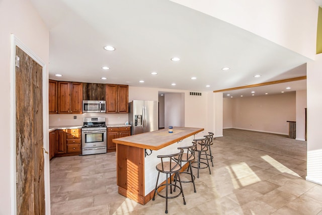 kitchen featuring a kitchen island, a breakfast bar area, and appliances with stainless steel finishes