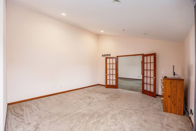 spare room with carpet, french doors, and lofted ceiling