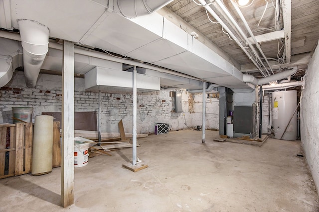 basement featuring heating unit, electric panel, and gas water heater