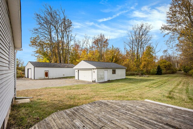 6700 Bethuy Rd, Ira, MI 48023 - view of green lawn with a detached garage, an outdoor structure, and a wooden deck