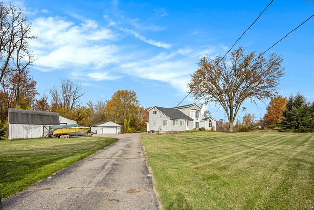 6700 Bethuy Rd, Ira, MI 48023 - view of front of property with a detached garage, an outdoor structure, and a front yard