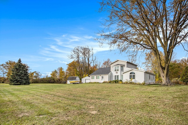 view of front of house with a storage shed and a front lawn