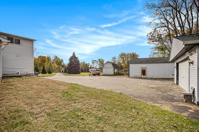 view of yard with a storage unit and a garage