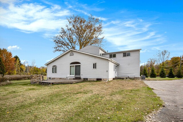 6700 Bethuy Rd, Ira, MI 48023 - rear view of property with a yard, a wooden deck, and asphalt driveway