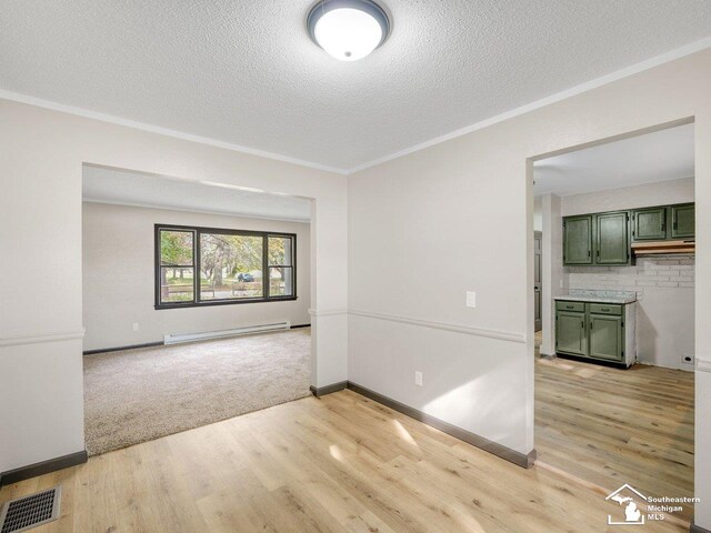 6405 Stillwater Ct, Erie, MI 48133 - spare room featuring a baseboard radiator, crown molding, light wood-type flooring, a textured ceiling, and baseboards