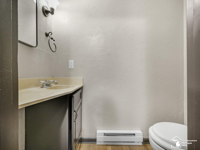6405 Stillwater Ct, Erie, MI 48133 - bathroom featuring a baseboard radiator, vanity, toilet, a textured wall, and wood finished floors