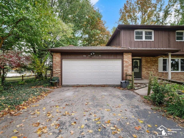 6405 Stillwater Ct, Erie, MI 48133 - view of front of house with driveway, brick siding, an attached garage, and board and batten siding