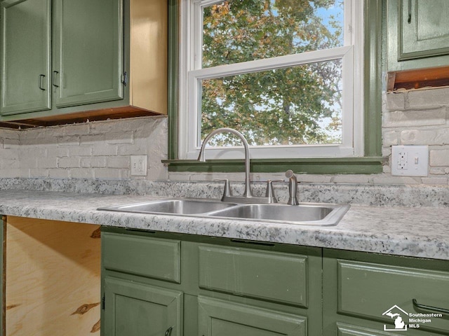 6405 Stillwater Ct, Erie, MI 48133 - kitchen featuring green cabinetry, a sink, light countertops, and decorative backsplash